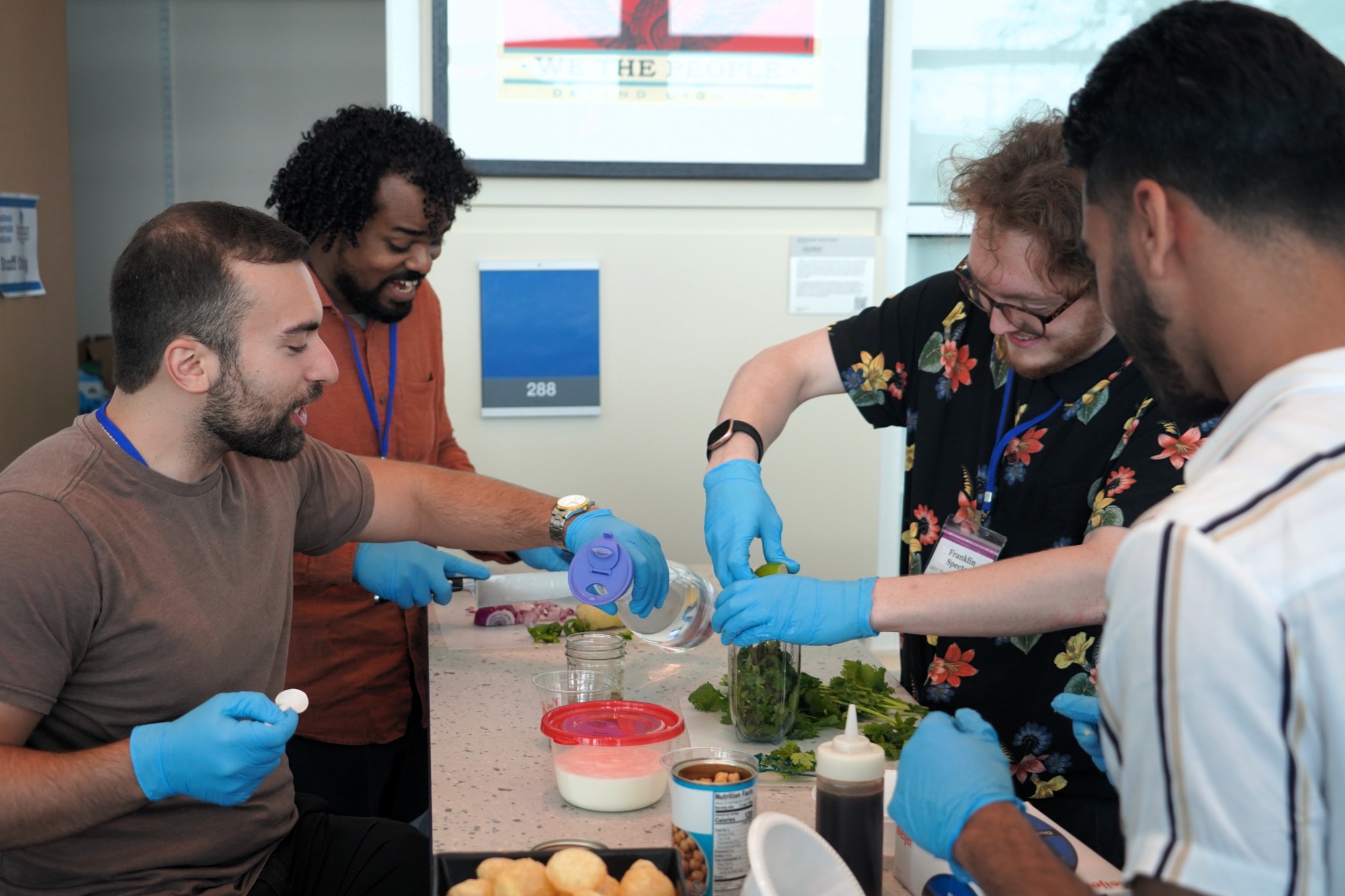 Four folks gathered around a table making food